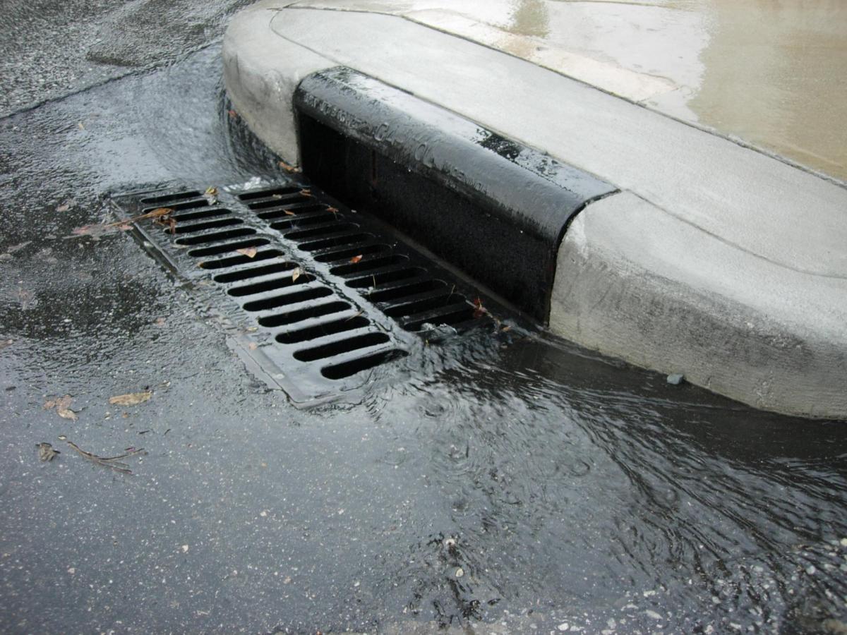 Storm drain with rainwater flowing into the grate